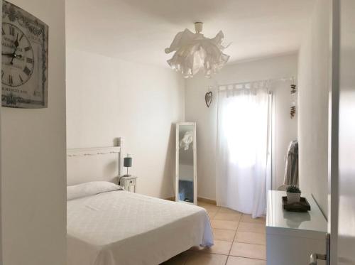 a bedroom with a bed and a clock on the wall at MY OCEAN HOME - Breathtaking location, Steps to the ocean, Spacious sea view, Fully Equipped and Well-Furnished with Private Entrance and High-Speed Fiber Optic Internet in Corralejo