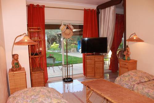 a living room with a tv and a couch at La Villa Topi in Antibes