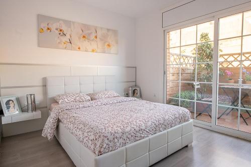 biała sypialnia z łóżkiem i oknem w obiekcie Kamelly w mieście Badalona