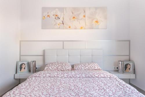 a bedroom with a bed with two pictures on it at Kamelly in Badalona