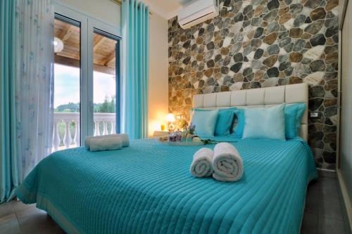 a bedroom with a blue bed with towels on it at Villa Zoi in Pelekas
