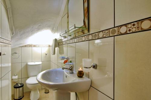 a white bathroom with a sink and a toilet at Villa Zoi in Pelekas