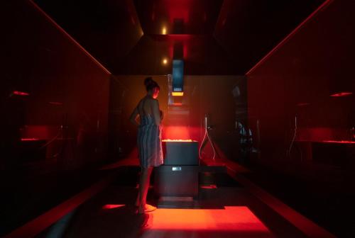 a person standing in a dark room with red lights at La Roccia Wellness Hotel in Cavalese