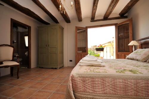 a bedroom with a bed and a chair and a window at Els Canterers in Miravet