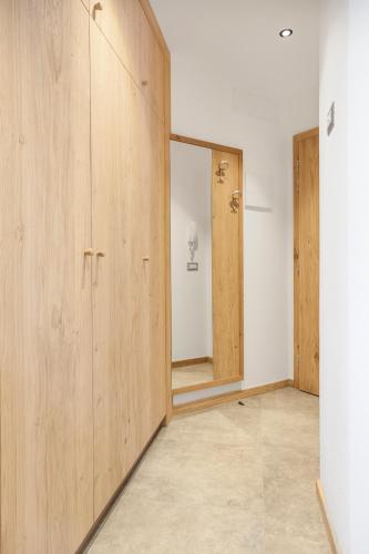 an empty room with wooden cabinets and a mirror at VillaGiardino - Lake in Molveno