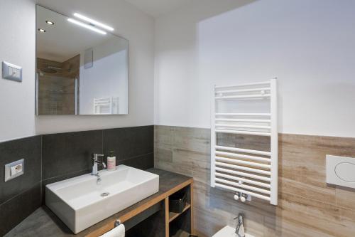 a bathroom with a white sink and a mirror at VillaGiardino - Lake in Molveno