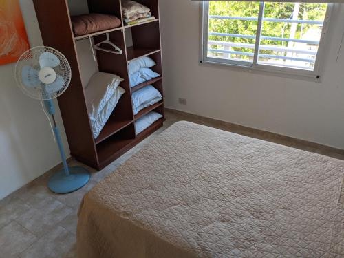 Una habitación con ventilador de pie y un armario. en Calle 3 1526, en Santa Teresita