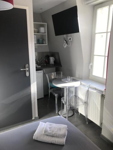 a room with a bed with a table and a kitchen at Smart Appart Caen République in Caen