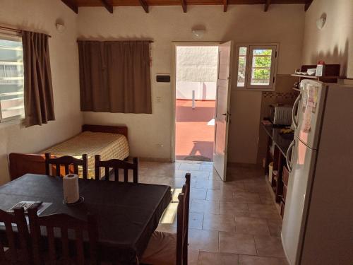 Una cocina y un comedor con una mesa y un refrigerador. en Calle 3 1526, en Santa Teresita
