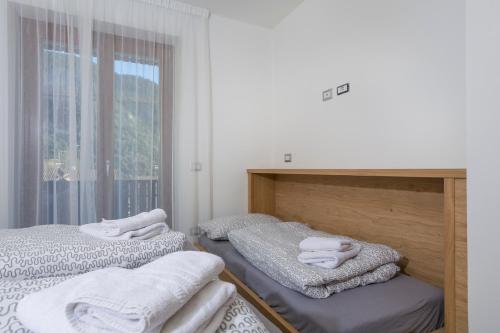 two beds in a room with towels on them at VillaGiardino - Lake in Molveno