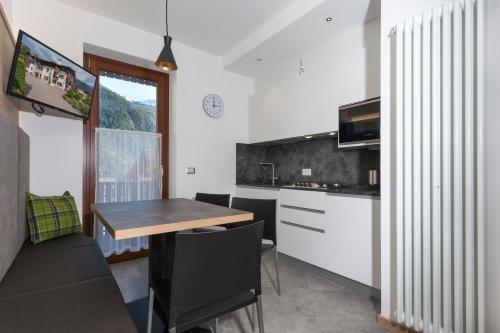 a kitchen and dining room with a table and chairs at VillaGiardino - Lake in Molveno