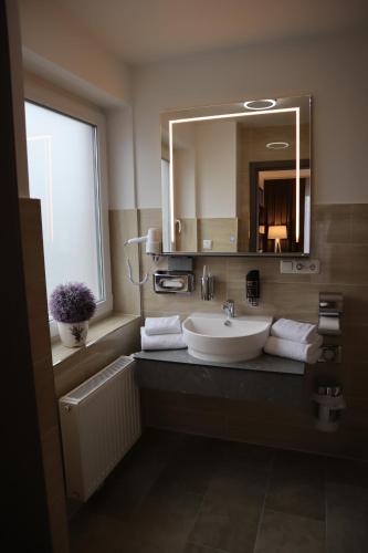 a bathroom with a sink and a mirror at Hotel Bispinger Hof in Bispingen