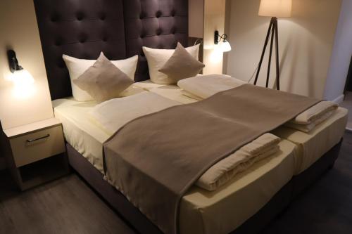 a bedroom with a large bed with a large headboard at Hotel Bispinger Hof in Bispingen