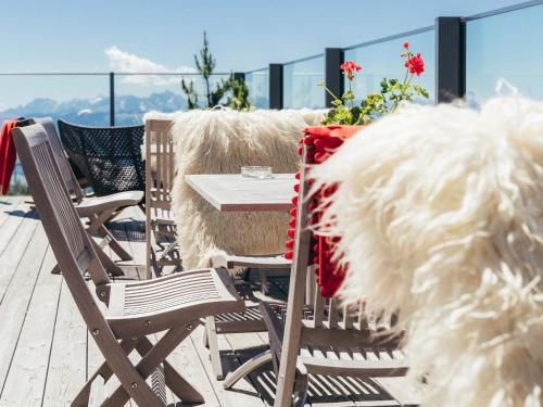 a table and chairs on the deck of a balcony at Alpinhotel Pacheiner in Treffen