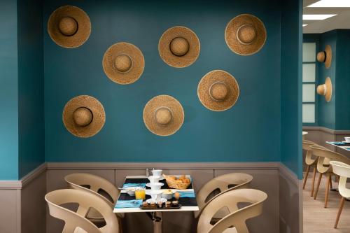 a restaurant with blue walls and straw hats on the wall at Paris Bastille in Paris