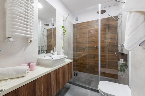uma casa de banho com um lavatório e um chuveiro em Warszawa Zachodnia Station Serviced Apartments em Varsóvia