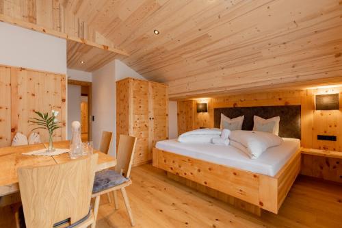 - une chambre avec un grand lit et un plafond en bois dans l'établissement Hotel Alpenstolz, à Mieders