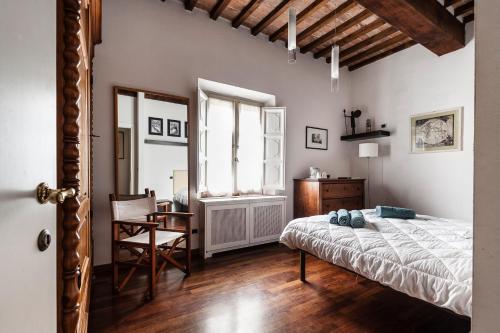a bedroom with a bed and a desk and a window at The Galileo Apartment in Pisa