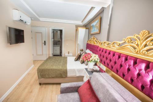 イスタンブールにあるAtlantis Royal Hotelのベッドとソファのあるホテルの部屋