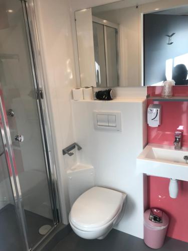 a bathroom with a toilet and a sink and a shower at Smart Appart Caen République in Caen