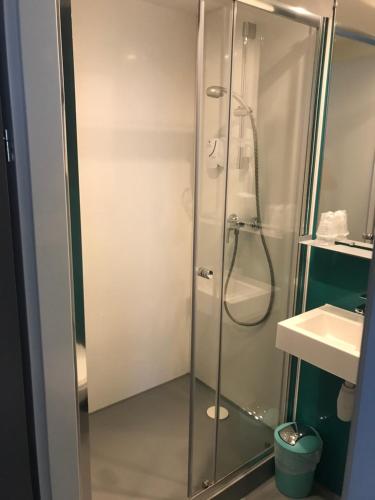 eine Dusche mit Glastür im Bad in der Unterkunft Smart Appart Caen République in Caen