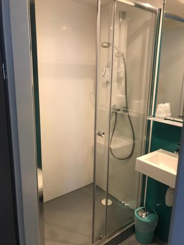 a shower with a glass door in a bathroom at Smart Appart Caen R&eacute;publique in Caen
