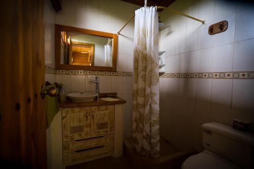 a bathroom with a sink and a shower curtain at Chez Manany Galapagos Ecolodge in Puerto Villamil