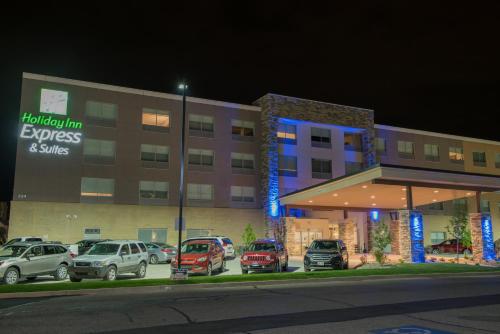 a hotel with cars parked in front of a parking lot at Holiday Inn Express & Suites - Orland Park Mokena by IHG in Mokena
