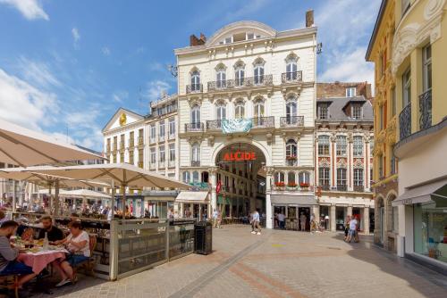 une rue de la ville avec des gens assis à des tables devant les bâtiments dans l'établissement NOCNOC - Le Cosy, Grand Place, à Lille