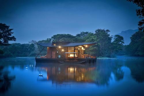 a house on a boat on a lake at night at Kalundewa Retreat in Dambulla