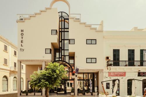 a large white building with a staircase on the side at Hotel Fly in Gallipoli
