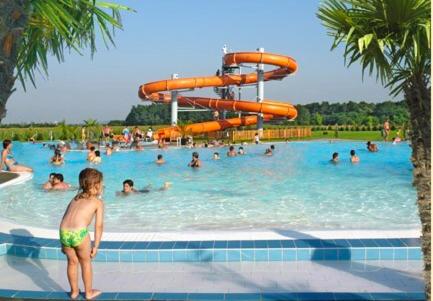 a young child standing in a swimming pool at Don Quijote Középkori Panzio és Étterem in Lenti
