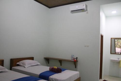 a room with two beds and a sink in it at Arrys Watukarung Surfcamp in Kalak