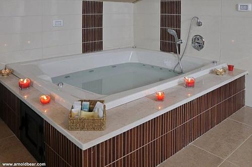 a large bath tub with candles in a bathroom at A Window to Kinneret in Safed