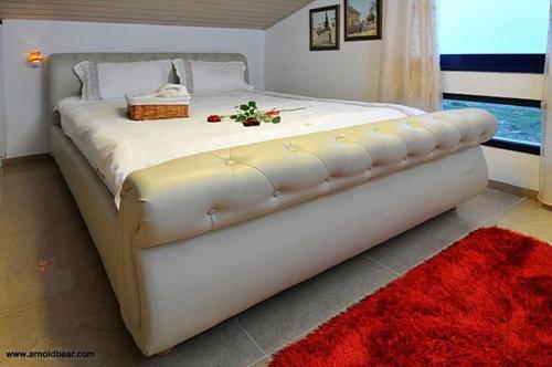 a large white bed in a room with a red rug at A Window to Kinneret in Safed