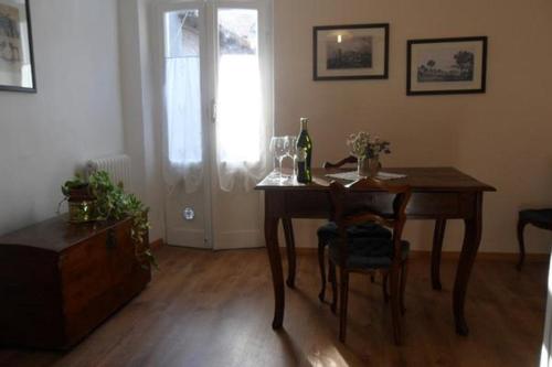 una mesa de comedor con una botella de vino. en Il Castello Di Dante, en Falconara Marittima