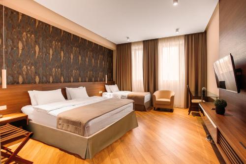 a hotel room with two beds and a television at Hotel Tbilisi Tower in Tbilisi City