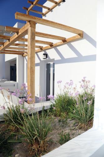a white house with a wooden pergola at Irida Vacation suites in Kastraki Naxou