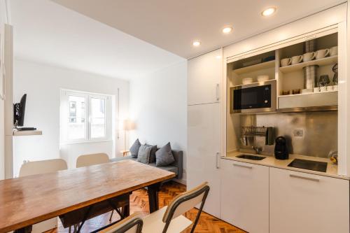 a kitchen and dining room with a table and chairs at Carmo Apartments in Lisbon