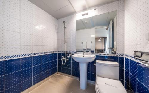 ein Badezimmer mit einem Waschbecken, einem WC und einem Spiegel in der Unterkunft BENIKEA San&Bada Jumunjin Resort in Gangneung