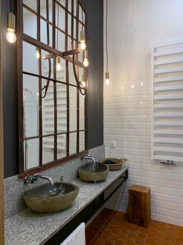 two sinks in a bathroom with a large mirror at Folwark Wąsowo in Wąsowo