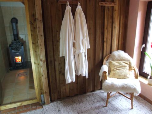 a room with a chair and towels hanging on a wall at Hof-Solgaard in Loit