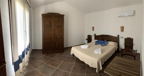 1 dormitorio con cama y tocador de madera en Agriturismo Turudhis, en Tortolì