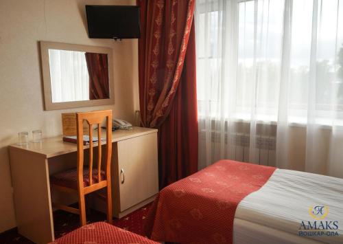ヨシュカル・オラにあるAMAKS City Hotelのベッドルーム1室(ベッド1台、デスク、窓付)