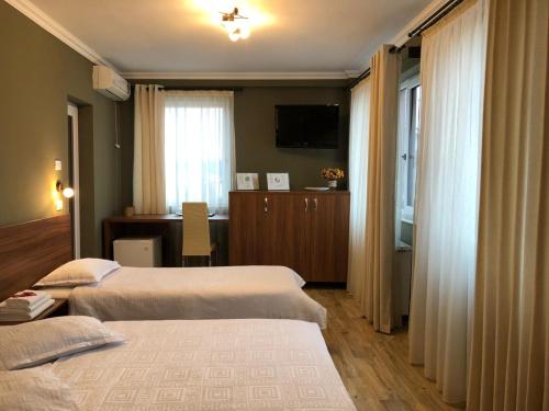 a hotel room with two beds and a television at Pension Aroma in Baile Felix