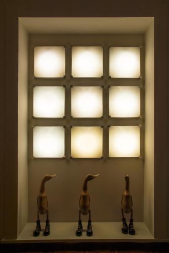 two birds sitting on a shelf in front of lights at Hotel Diana & Depandance in Lucca