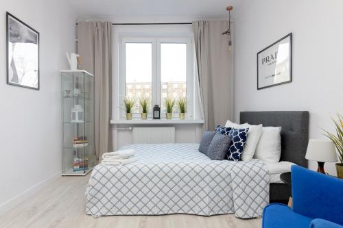 a white bedroom with a bed and a window at Stara Ochota Vogue Apartment in Warsaw