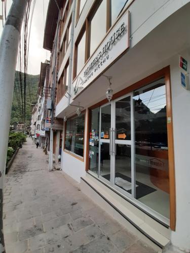 a building with windows on the side of a street at Flower's House MachuPicchu in Machu Picchu