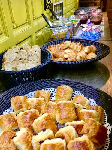 a table with three baskets of bread and pastries at Hôtel du Commerce in Montauban