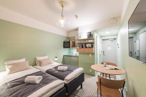 a bedroom with a bed and a small table at Forenom Aparthotel Jyväskylä in Jyväskylä